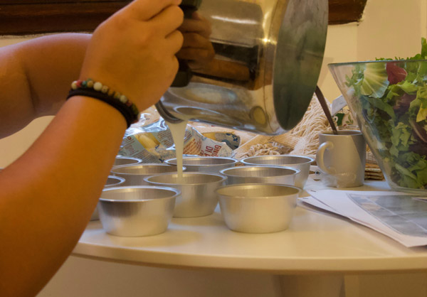 a person pouring mixture into baking trays