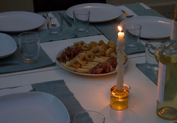 a candle and food platter on a set table
