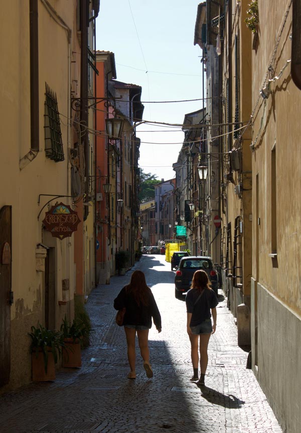 two people walking along a small European street