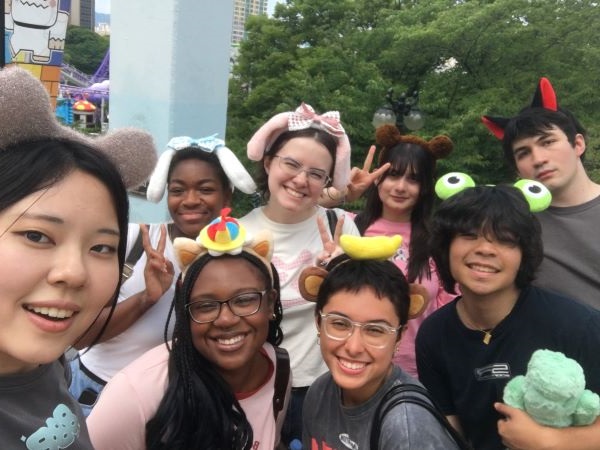 Eight study abroad students smiling at the camera in a group, all wearing small colorful headbands