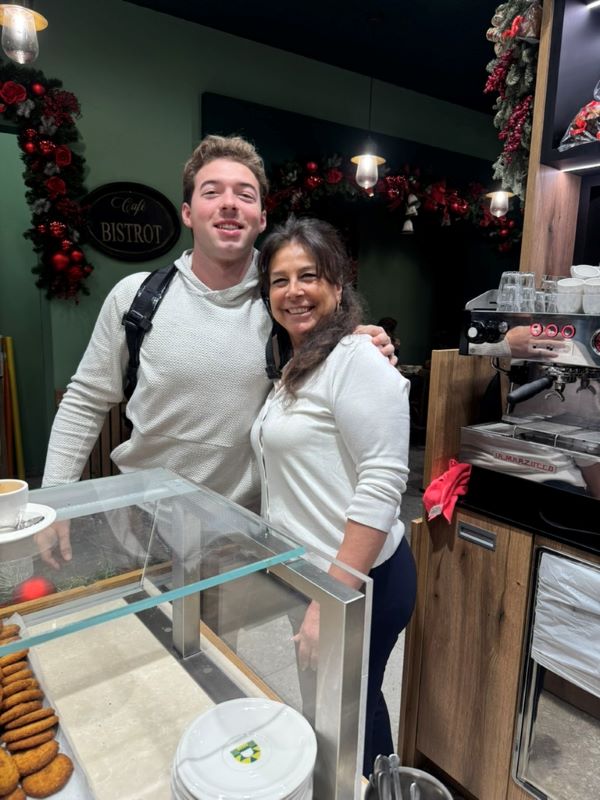 Study abroad student posing for photo with bakery employee