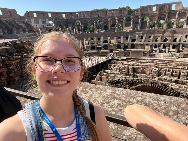 A study abroad student taking a selfie in front of an ancient building