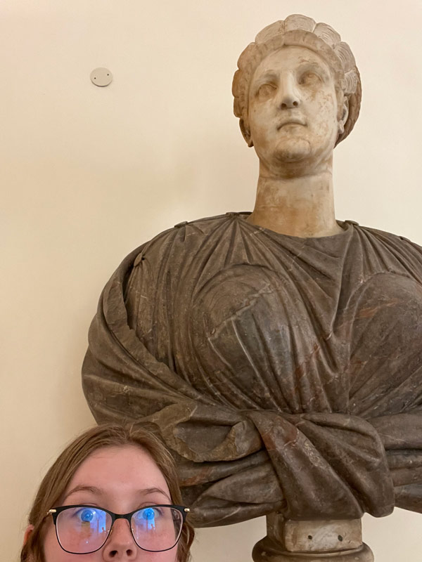 A study abroad student taking a selfie with a statue