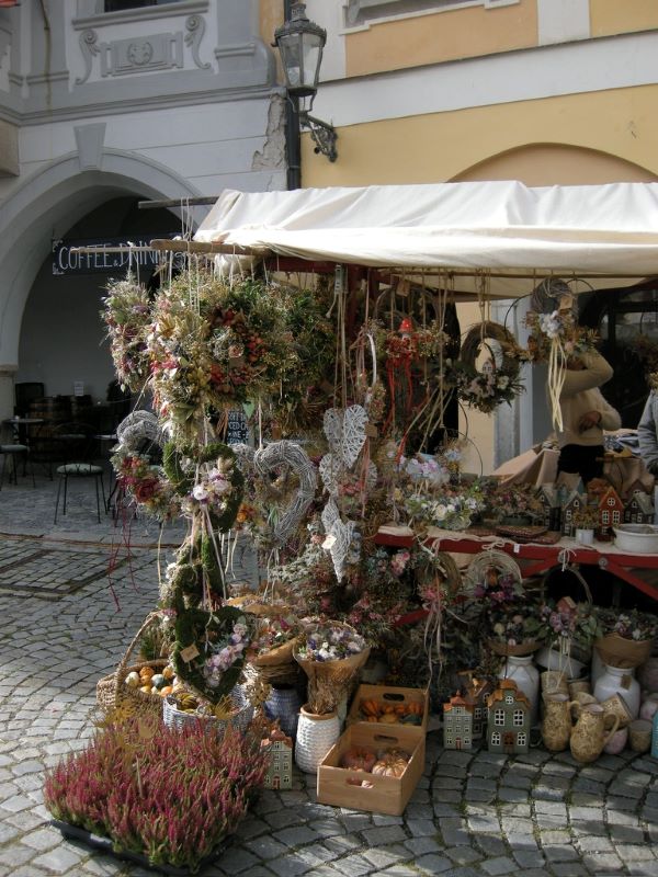 An outdoor market stall covered in many varities of dried flowers, including multiple wreaths hanging from the top
