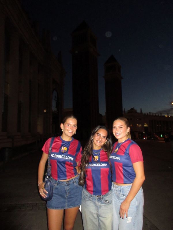 Three study abroad students wearing matching jerseys