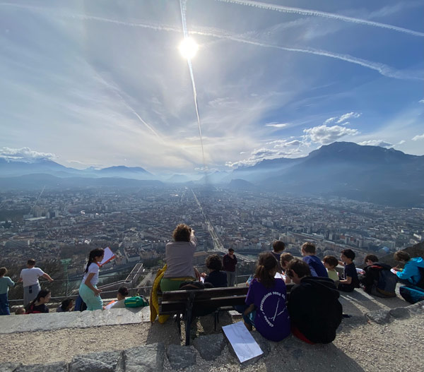 A group of study abroad students sitting on a ledge looking at a city
