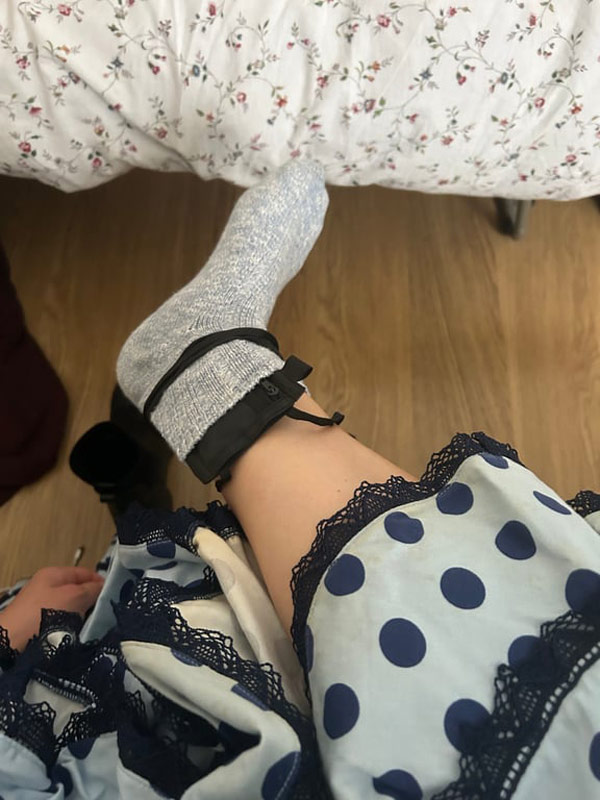 A person's leg with a blue and white polka dot dress