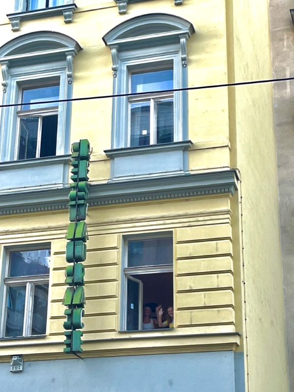 Study abroad students waving goodbye from apartment window