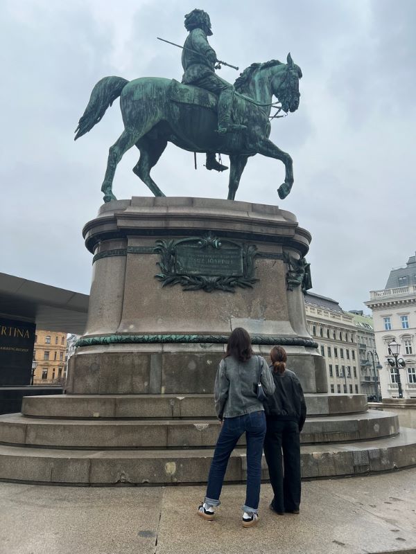 Study abroad students looking up at the statue outside of the Albertina Museum in Vienna, Austria