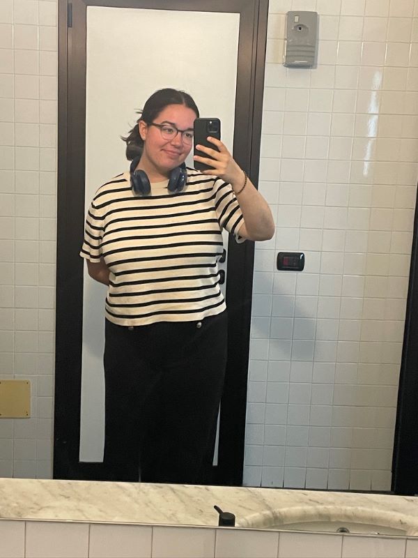 A study abroad student taking a selfie in a bathroom mirror