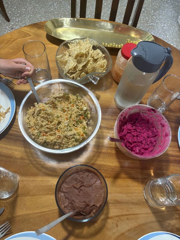 A table indoors full of dishes of food and glasses of water