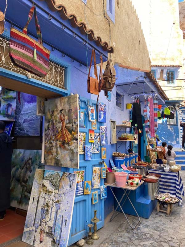 A blue building with paintings and other items on the wall
