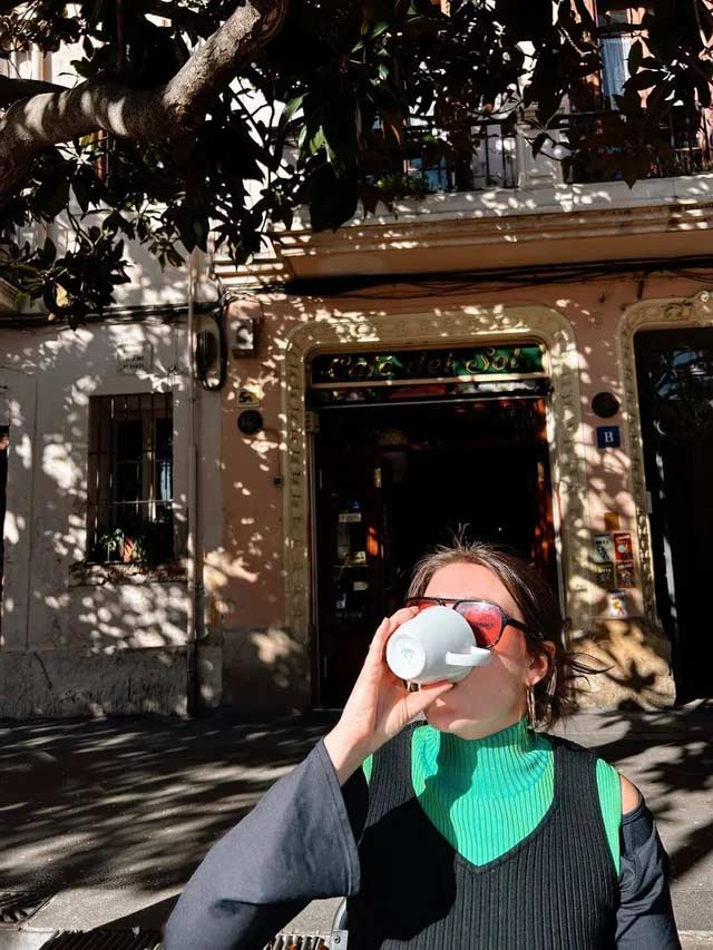 A woman drinking coffee under the sun