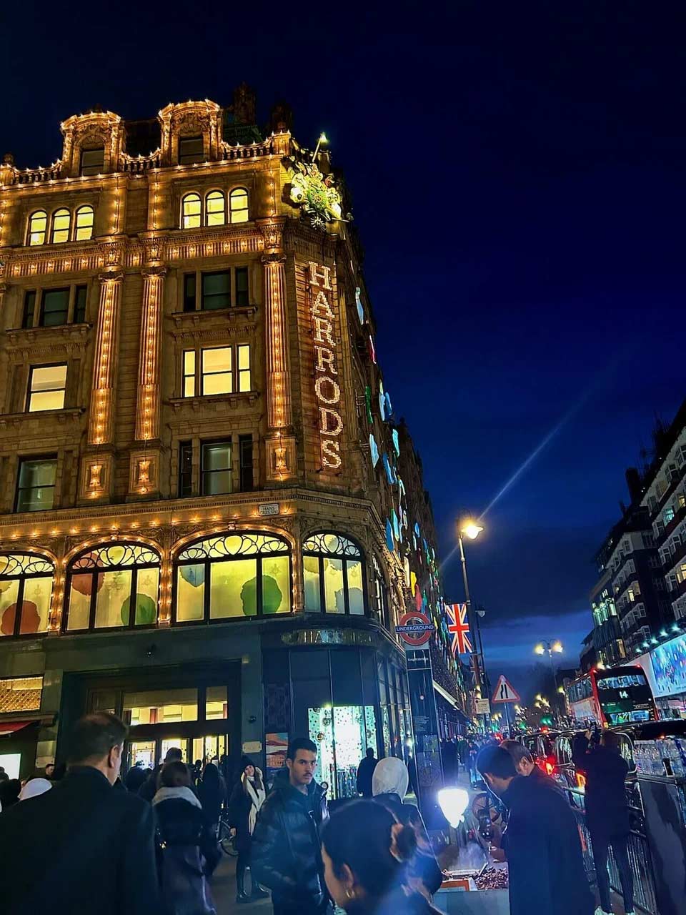 Outside Harrods at night in London with people on the street