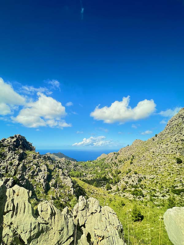 A rocky landscape with blue sky and clouds