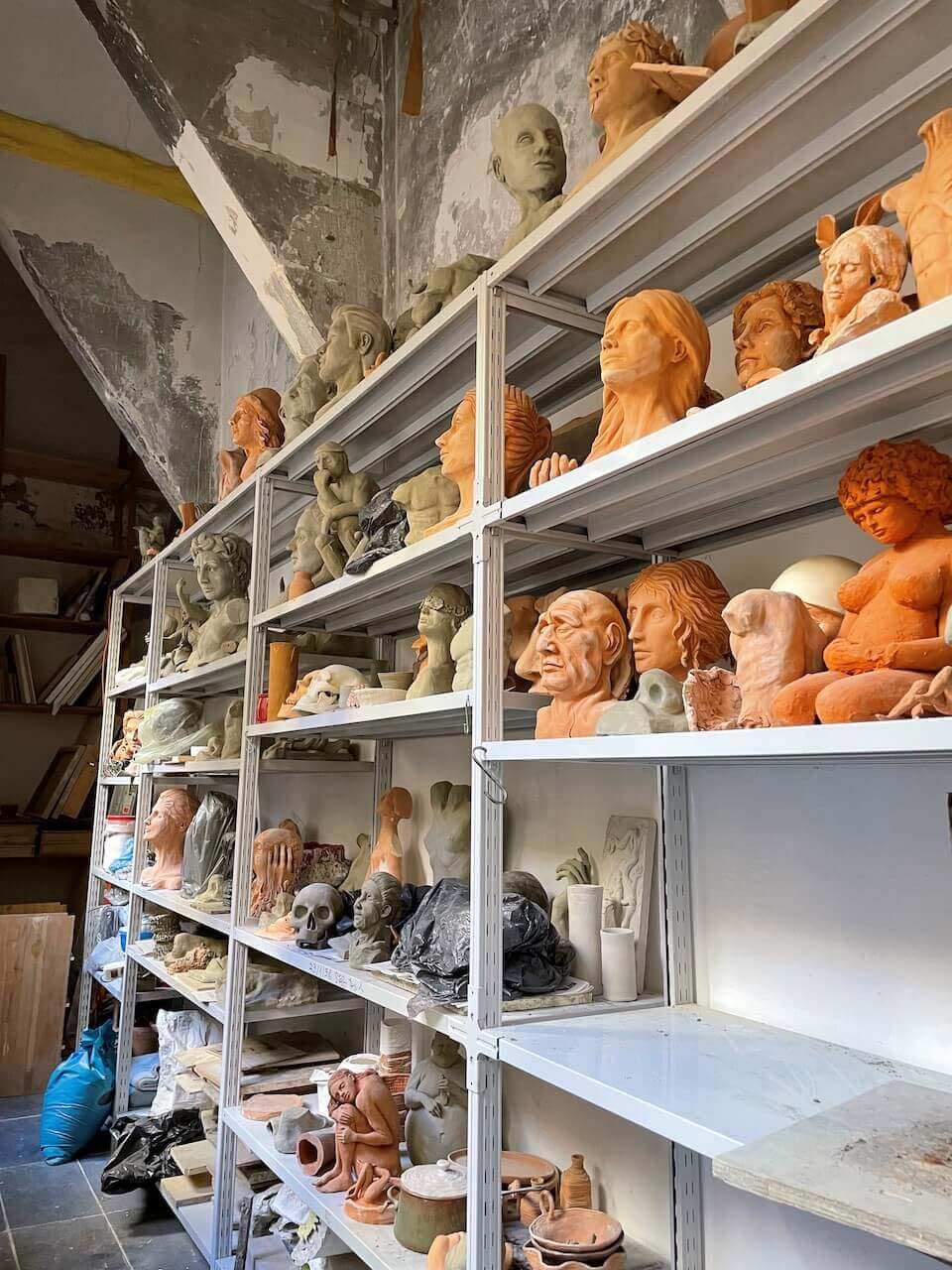 Shelves holding sculpture and art pieces in an art studio