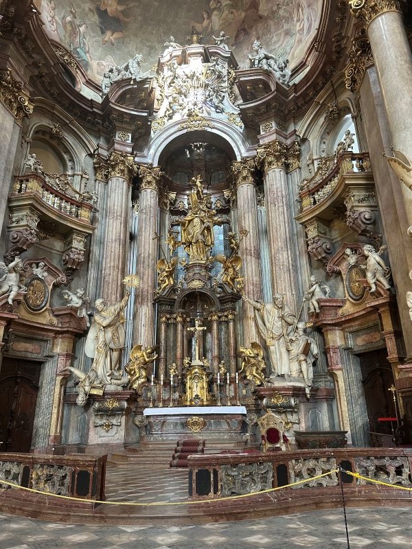 An intricately decorated section of a building's interior, featuring many statues and gold varnishings