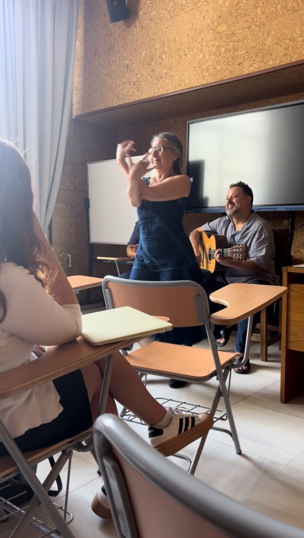 Professor dancing flamenco in classroom with guitarist 