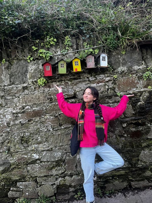 Study abroad student posing for photo by a couple of tiny homes