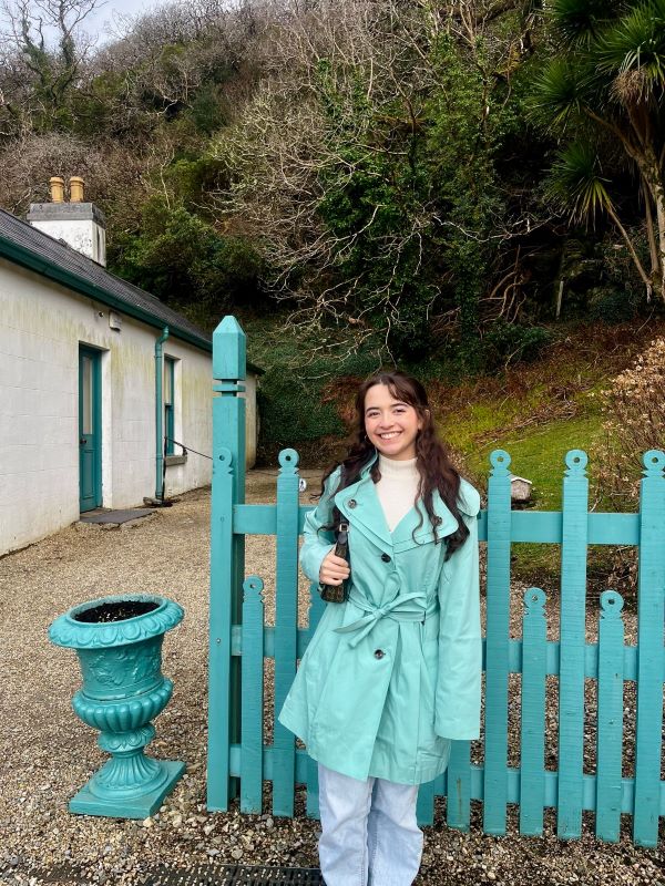Study abroad student wearing teal next to teal fence