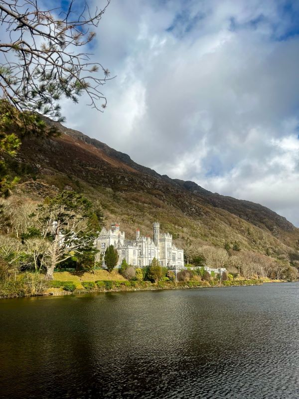 Kylemore Abbey next to mountain and body of water 