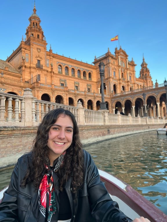 A study abroad student in a boat in front of a building
