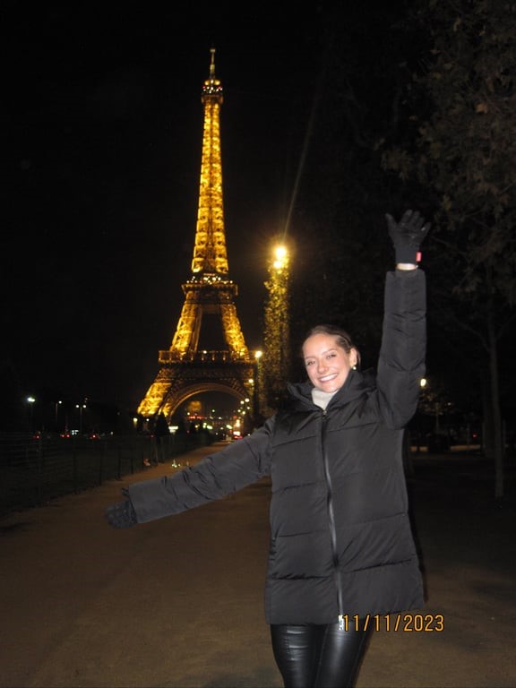 A study abroad student posing in front of a lit tower