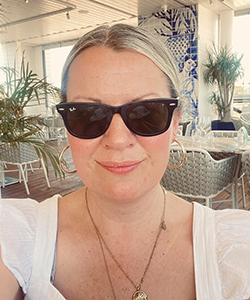A person in sunglasses smiling at the camera