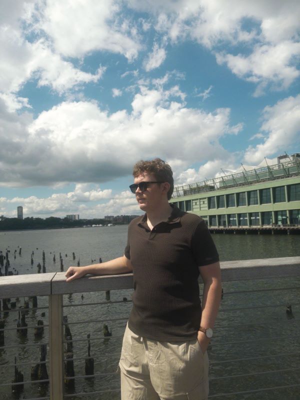 A study abroad student wearing sunglasses and turned slightly to the side in an outdoor setting