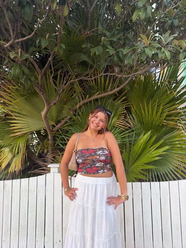 A study abroad student standing outdoors and smiling at the camera