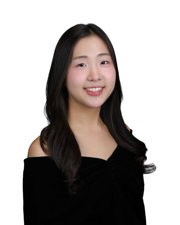 A study abroad student with long dark hair smiling at the camera against a white background