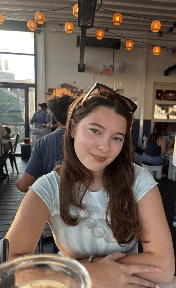 A study abroad student sitting indoors while smiling at the camera