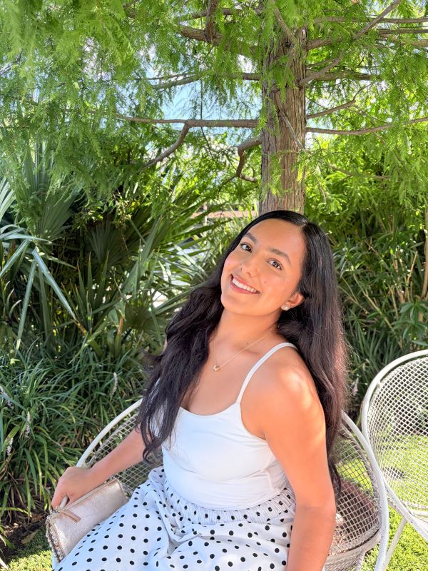 A study abroad student sitting outdoors and smiling at the camera