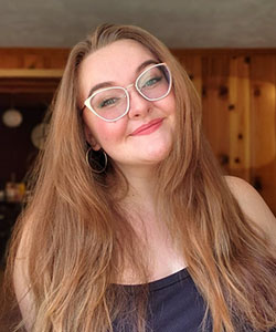 A person with long hair wearing glasses